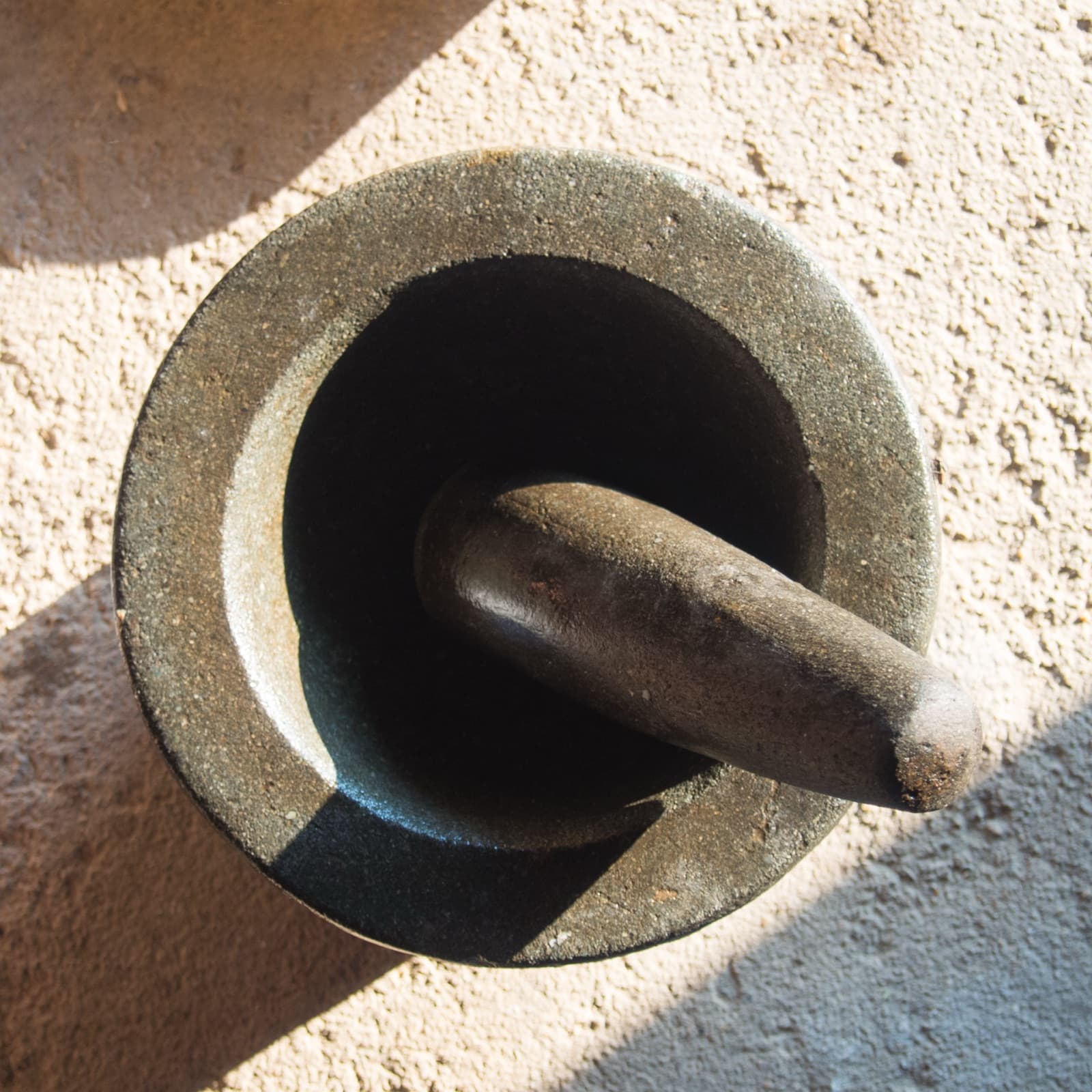 A traditional stone mortar and pestle used for grinding herbs and spices